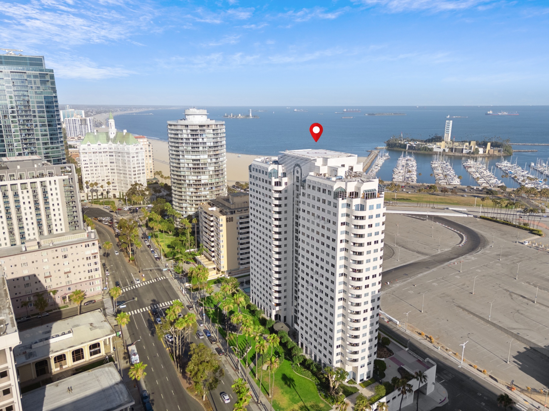 Aerial drone view of Harbor Place Tower with ocean, beach, and marina in the background